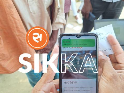 A person holding phone and using Sikka